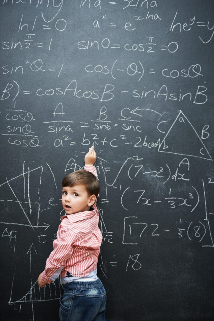 What a little genius. Studio shot of a young boy with a blackboard full of math equations.